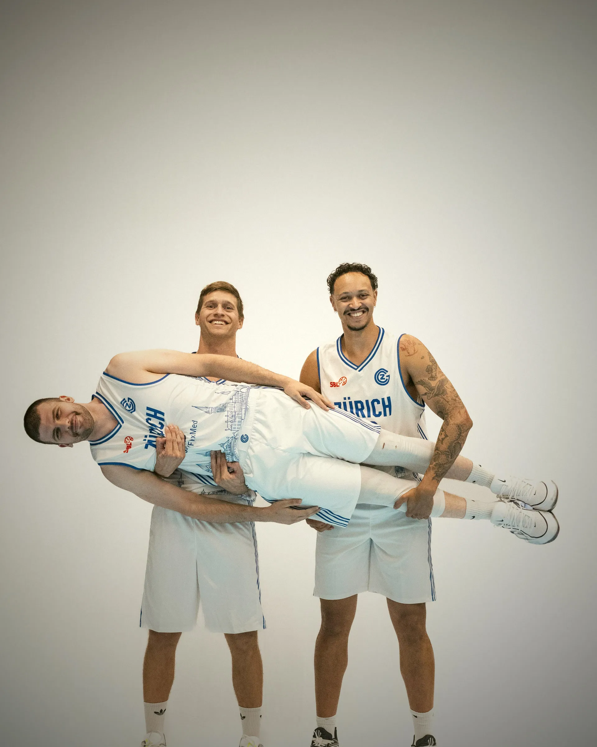 Ein Spieler trägt seinen Teamkollegen quer über den Armen, beide lachen