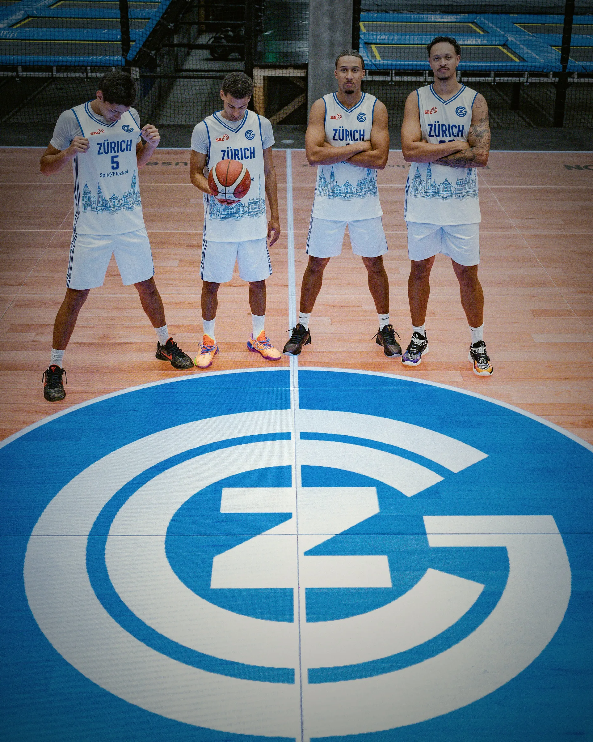 Vier Spieler stehen von oben fotografiert auf dem GC-Logo am Mittelkreis