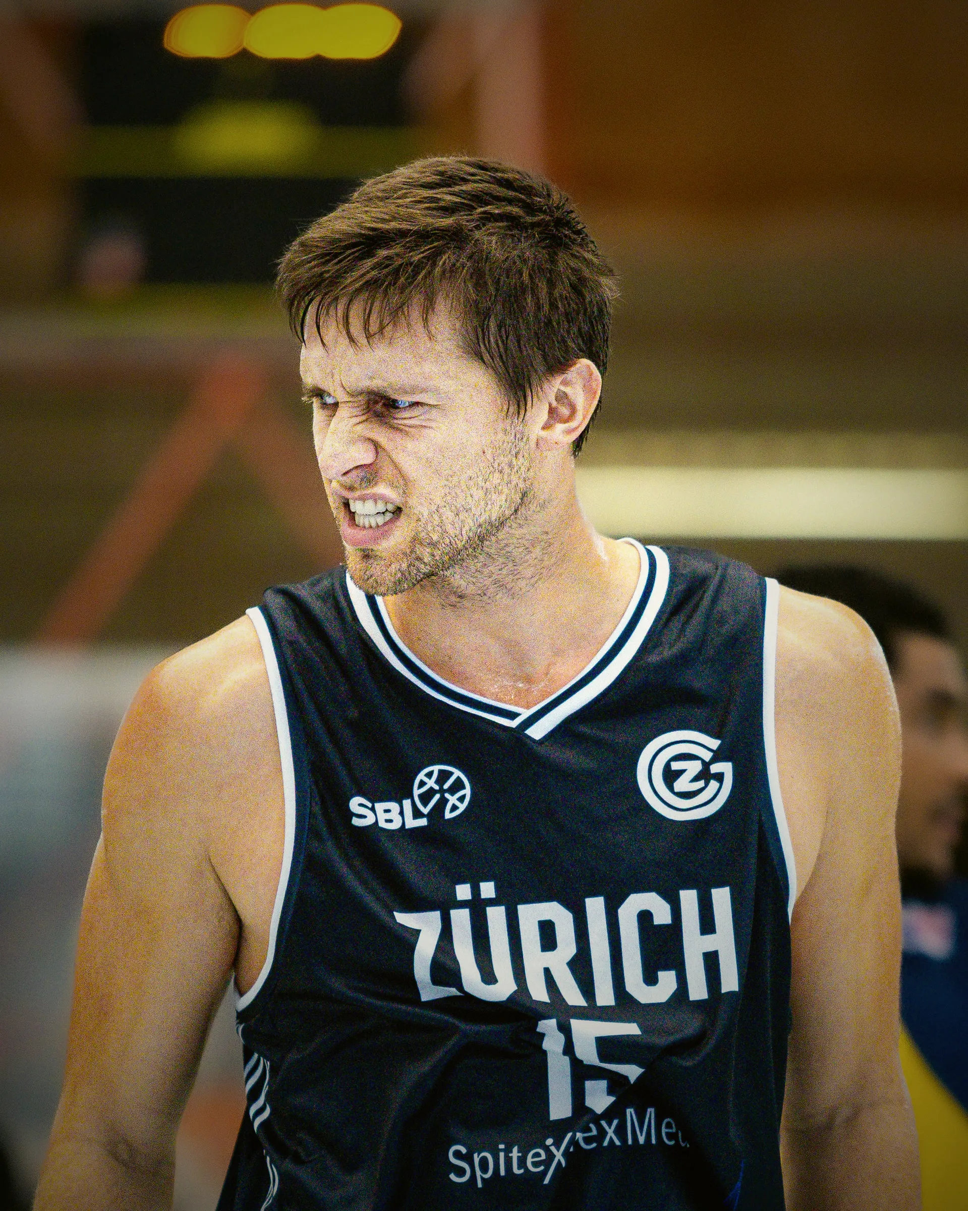 Spieler mit der Nummer 15 im dunkelblauen Auswärtstrikot, angespannter Blick während des Spiels